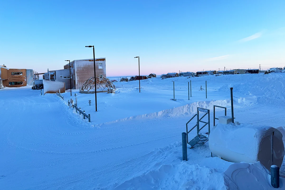 Outdoor setting, building with lights and a generator, covered in snow.