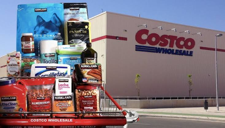 mubeitech's tweet photo. Costco 的自有品牌 Kirkland，2025 年一年卖了 900 亿美元。

900 亿是个什么概念？
造飞机的波音，一年营收 890 亿。
联邦快递 880 亿。
日化巨头宝洁 840 亿。
华尔街的富国银行 800 亿。
一个印在坚果、垃圾袋和卫生纸上的超市白牌，年营收干翻了一批世界五百强巨头。

只要逛过传统超市，大家对“自有品牌”都有固有印象：
便宜、包装糙、质量凑合，专门给不想花钱的人应急。
但 Kirkland 完全反过来了。
不仅买的人抢着用，甚至很多中产办会员，就是为了买它的白牌。
它到底是怎么把一个超市贴牌，做成全美最大商业帝国之一的？

这里面第一道反常识的规定，是加价上限。
传统零售商卖货，加价率动辄 25% 到 50%，百货公司甚至能加到 100%。
加价越高，利润越厚。
但 Costco 给自己定了一条死规矩：
外部大牌商品，加价率绝不能超过 14%。
自己的 Kirkland，上限也锁死在 15%。
多一分钱都不许加。

不加价，买手怎么考核？
普通的超市买手，年终奖看你给公司赚了多少毛利率。
你把供应商的价格压下来，差价进超市口袋。
Costco 完全倒过来。
买手不考核毛利率百分比，只考核周转量。
比如一个仓库里，这款商品单周能不能卖到 4000 美元。
更绝的是，只要买手跟工厂谈下更低的成本，内部机制强制要求：
立刻把货架上的零售价降下来，全额还给会员。
买手不许截留差价，公司也不许把省下来的钱做成利润。

那利润从哪里来？
答案在会员卡上。
Costco 根本不靠卖商品赚钱，商品的差价只要能覆盖仓储和运营成本就行。
它的利润来源，是每年收取的会员费。
全球几千万会员，超过 90% 的续费率。
只要会员觉得在这买东西便宜、品质好，续费就不会断。
商品是诱饵，会员费才是现金牛。

但光便宜还不够。
质量如果跟不上，大牌一做促销，白牌立刻就会被打回原形。
Kirkland 的第二个杀招，是货架主权。
平常去大型超市，货架上动辄陈列几万甚至十万种商品。
但走进程清一色大铁架的 Costco，全店通常只有大约 4000 种商品。
这意味着什么？
在大部分品类里，货架上只允许存在两个选择：
一个是最头部的全国大牌，另一个就是 Kirkland。
4000 个席位，成了全美最极端的稀缺资源。

这就逼出了一个极其残酷的商业游戏。
Costco 对代工厂的要求非常硬：
Kirkland 的品质，必须持平甚至超过行业第一的大牌，但价格必须比大牌便宜至少 20%。
现任首席执行官瓦克里斯（Ron Vachris），1982 年在仓库里开叉车出身，一路干到最高层。
所有 Kirkland 新品，最后一关必须由他亲自签字。
当年团队拿了一款培根鸡蛋三明治找他审批。
他尝完直接否决了：
品质跟市面上的大牌差不多，这不行，打不赢。
他让买手回去找工厂重新做：
把里面最高价值的培根肉，直接增加 40% 的蛋白质含量，而且零售价一分钱都不能涨。
工厂回去反复调试，硬把加了近一半培根的三明治做出来了，他才松口放行。

你可能会问：大牌工厂又不是傻子，为什么愿意接这种苦活？
利润率往往被压到个位数，还要用最高标准给别人做贴牌，甚至自己打自己？
因为没人能拒绝 Costco 的走量诱惑。
接了 Kirkland 的单子，只要保质保量，一条产线全年 24 小时开足马力。
没有退货扯皮，没有账期拖欠，更没有传统超市名目繁多的入场费和堆头费。
金霸王替它做电池，星巴克替它烘焙咖啡豆，金佰利替它造纸尿裤。
如果不接呢？
Costco 会直接找行业第二名做代工，然后把第一名踢出仓库。
在只有 4000 个席位的货架面前，失去这个入口，就等于把几百亿美元的市场拱手让给死对头。

还有一个巨大的成本差额，很多人根本没算过：
广告费。
宝洁一年要在电视、社交媒体和明星代言上砸掉几十亿美元。
每买一瓶大牌洗发水，消费者都在替它的广告牌和公关团队买单。
Kirkland 在营销和广告上的预算是多少？
整整 0 美元。
它没有公关部，不请代言人，不在时代广场打大屏。
省下来的所有营销费用和中间渠道抽成，全部填进了产品原料里。
同样卖 10 块钱，大牌拿 3 块钱做广告，Kirkland 把 3 块钱多放成了培根和优质原料。

这就是那台运转了三十年的机器。
自限毛利的定价规则，加上极端稀缺的货架控制权，把全球顶级供应链的开工率吃满；
再用零广告开销和会员制，把全部规模红利倒灌给消费者。
当一个白牌的品质追平了大牌，价格便宜两成，还能一年卖出 900 亿的时候，
它早已不是普通的超市贴牌。
它是一家披着零售外壳的供应链巨头。