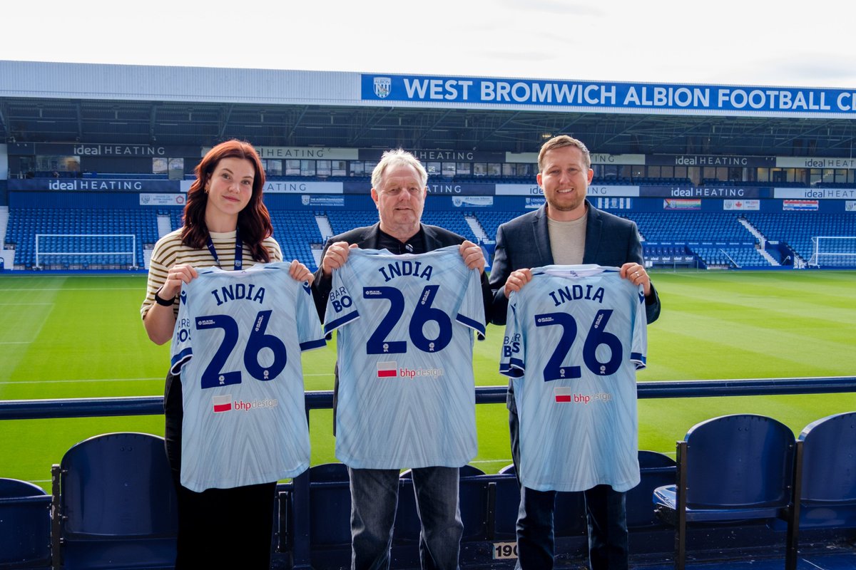 Dave Bloxham, of BHP Design (centre) with Sophie Osbourne (left) and Jonathan Ward, Deputy Director (right) all holding WBA third kit shirts with India 26 on the back.
