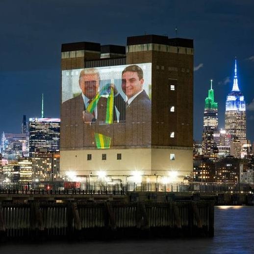 republiqueBRA's tweet photo. 🇺🇸 🇧🇷 Organização Choose Democracy projeta, em Nova York (EUA), imagens geradas artificialmente de Flávio Bolsonaro entregando a faixa presidencial do Brasil a Donald Trump. https://t.co/DIFHEBZkBp