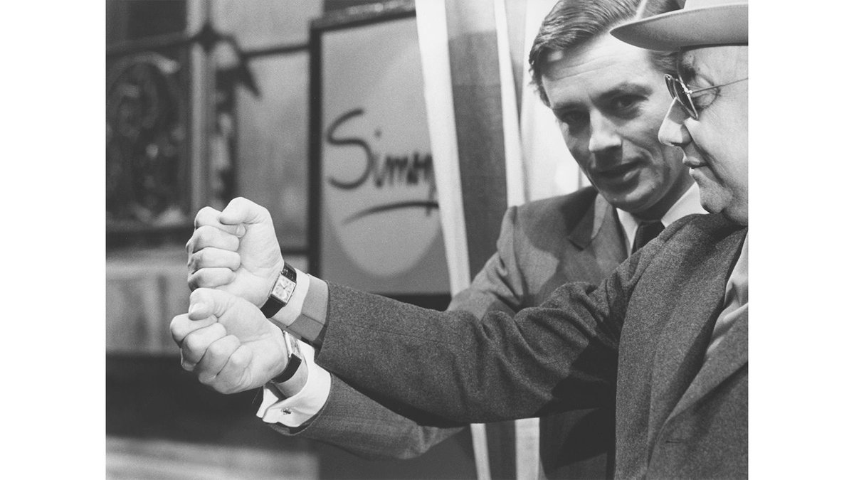 IMWDb_'s tweet photo. During Un Flic, Alain Delon discovered that Jean-Pierre Melville also wore a curved @Cartier Tank. A photograph catches the actor and director comparing wrists. Neither watch has a documented reference number. https://t.co/6why6AAXsP