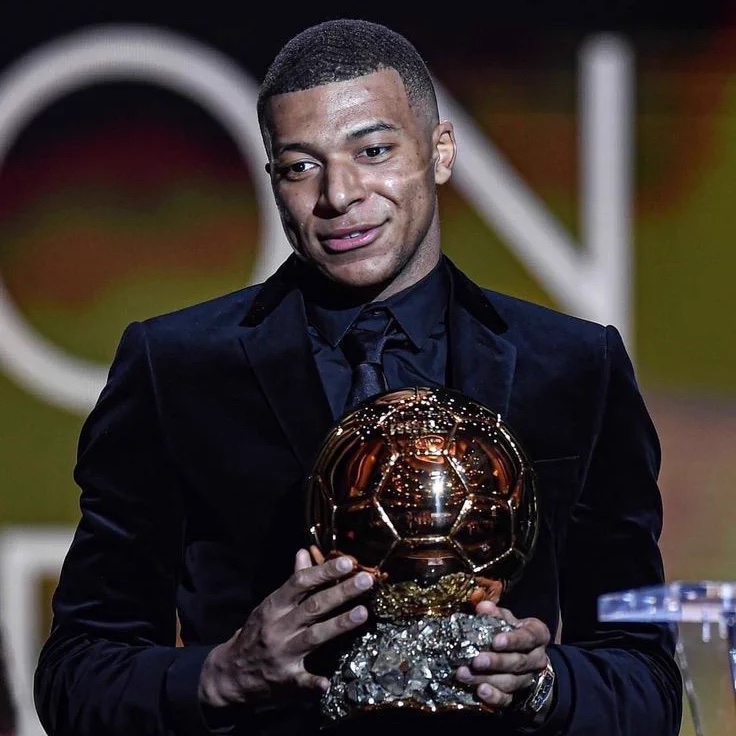 MadridXtra's tweet photo. 🚨 Kylian Mbappé points to pictures of Cristiano Ronaldo holding the Ballon d'Or on Real Madrid's wall of photographs:

"Maybe my picture will be here soon, who knows? IT'S TIME! IT'S TIME! Maybe this year is a good year for that!" @TheAthleticFC https://t.co/c2HkPMdyGu
