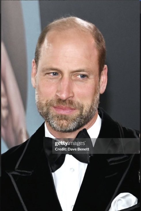 QLoTII's tweet photo. Let me tell you what happened in Leicester Square tonight, because it was better than the film.

The Princess of Wales has not walked a red carpet since May 2022. In between came the year the family does not discuss: the surgery, the diagnosis, the video from the garden bench, the chemotherapy, the months when the country quietly counted the days. Tonight she walked one again.

She wore purple. Deep plum, Jenny Packham, cut lower than she has ever dared, the colour of queens. Her hair was half up, so that you could see the earrings, and the earrings were Diana's pearls. At her throat, on a rope of pearls to the waist, hung an amethyst heart the size of a walnut. Queen Alexandra gave it to the Queen Mother in 1923, the year she married into the family. It has been worn through a war, an abdication and a century of clever men underestimating the women who wore it.

This morning a book went on sale calling that Queen petty and the King a lottery winner on the morning Diana died. The family's reply to a week of it has been one sentence. Tonight the future Queen answered without one: she wore the Queen Mother's heart and Diana's pearls at the same time, and let the flashbulbs do the talking.

And William. Black tie, half a step behind her on the carpet, in her light rather than his own, with the look of a man who walked behind a coffin at fifteen and has spent every year since making sure she would never be alone on a carpet, or in a hospital, or anywhere.

She looked magnificent. Not because of the dress, though it was perfect, and not because of the necklace, though it was a hundred years of the family on a single strand. She looked magnificent because she looked well, and happy, and unafraid.

The book will be in the bargain bins by Christmas. The amethyst goes back to the vault, until another woman wears it on another night for reasons nobody will need to explain. That is the difference between a family and a grievance. One of them lasts.