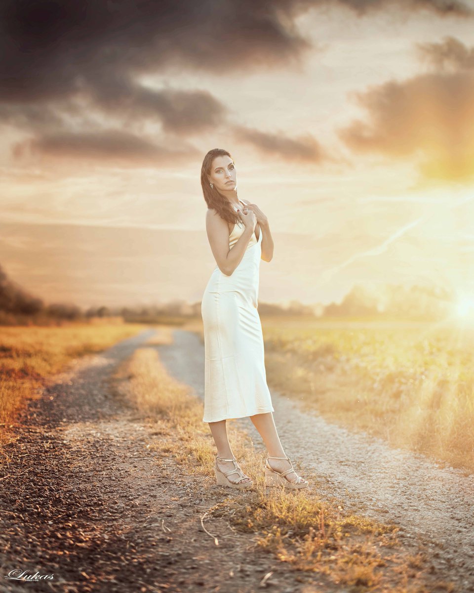 HaileyBenkitt's tweet photo. Dressed in golden hues against the dusky evening, she stands elegant and serene. The sunset highlights every detail, blending seamlessly with the moody, painted sky. Spring feelings, happy. https://t.co/XGqIsbr7dT