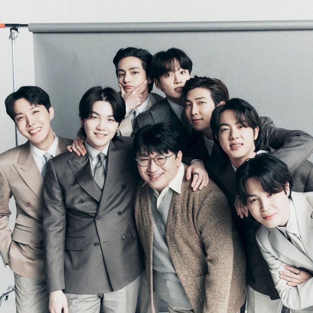 Eros_AgustD's tweet photo. บทสรุป 7คน7วัน7เรื่อง(ไถ่ไปอ่านก่อนได้)….อะไรคือ “แรงส่ง” ที่ทำให้รถไฟขบวนนี้วิ่งไกลเกินกว่ารางที่Bang Si-Hyuk และ BigHit เคยวางไว้ : Saveไว้อ่านตอนกิน☕️ ใครเห็นรูปแล้วเริ่มด่าในใจก็วางBiasก่อนอ่าน

ถ้าใครรู้จัก BTS มานานพอ จะรู้ว่าความสัมพันธ์ระหว่างอีอ้วนบังชีกับวงนี้ไม่ใช่เรื่องง่ายแบบ “ผู้สร้างสร้างวง → วงดัง → จบ” เพราะตั้งแต่ก่อนเดบิวต์จนถึงวันนี้ อีอ้วนบังชีเปลี่ยนแผนมาแล้วหลายรอบ สมาชิกทั้ง 7 คนก็เติบโตจนมีความคิดและเส้นทางของตัวเอง ขณะเดียวกันยังมีคนอีกกลุ่มหนึ่งที่ค่อย ๆ เข้ามาเปลี่ยนสมการทั้งหมด นั่นคือ ARMY แต่ถ้าจะเล่าเรื่องนี้ให้ครบจริง ๆ เราอาจต้องมองแบบรอบด้านว่ามันประกอบด้วย คนวางระบบ + ศิลปิน 7 คน + แฟนคลับนับล้านที่ช่วยกันผลักรถไฟขบวนนี้ไปข้างหน้า

👉 อดีต

ก่อนจะมี BTS แบบที่เรารู้จัก อีอ้วนบังชีมีแค่เด็กแรปเปอร์คนหนึ่งกับความคิดว่า “วงนี้ควรเป็นฮิปฮอป”

จุดเริ่มต้นของ BTS ไม่ได้เกิดจากแผนสร้างบอยกรุ๊ปที่ครบสูตร แต่เริ่มจาก RM ซึ่ง Pdogg นำเดโมมาให้อีอ้วนบังชีฟัง แล้วเขามองเห็นศักยภาพของเด็กคนนี้จนตัดสินใจดึงเข้ามาเป็นแกนสำคัญของโปรเจกต์ เดิมทีสิ่งที่อีอ้วนบังชีคิดไว้ใกล้เคียงกับ hip-hop crew มากกว่า idol group เน้นแรป การทำเพลง และตัวตนของศิลปิน แต่เมื่อสถานการณ์เปลี่ยน เขาก็เปลี่ยนโจทย์ด้วย เพราะถ้าต้องการให้ข้อความของเด็กกลุ่มนี้ไปถึงคนจำนวนมาก การอยู่ในระบบไอดอลที่มีทั้งเพลง Performance และเวทีขนาดใหญ่ย่อมเปิดประตูได้กว้างกว่า นั่นทำให้เด็กฝึกสายฮิปฮอปบางคนเลือกออกไป เพราะสิ่งที่กำลังจะกลายเป็น BTS ไม่ใช่สิ่งที่พวกเขาสมัครเข้ามาตั้งแต่แรกแล้ว

RM, SUGA และ J-Hope จึงกลายเป็นแกนฝั่งฮิปฮอปที่เหลืออยู่ ก่อนจะมี Jin, Jimin, V และ Jungkook เข้ามาประกอบกันจนเกิดวงที่ตอนแรกก็ดูเหมือนเอาคนละโลกมายัดไว้ในห้องเดียวกัน แต่กลับกลายเป็นส่วนผสมที่ทำให้ BTS มีเอกลักษณ์ขึ้นมาเอง RM เป็นแกนด้านความคิดและการสื่อสาร SUGA มีความเข้มข้นทางดนตรี J-Hope แข็งแรงด้าน Performance และพลังของทีม Jin ค่อย ๆ สร้างพื้นที่ของตัวเอง Jimin นำภาษาการเต้นที่แตกต่างเข้ามา V มีเสน่ห์แบบที่ไม่จำเป็นต้องพยายาม ส่วน Jungkook เป็นเด็กที่มีศักยภาพสูงมากแต่ต้องค่อย ๆ ทลายกำแพงความขี้อายของตัวเอง

สิ่งที่น่าสนใจคืออีอ้วนบังชีเองก็ไม่ได้มองสมาชิกทุกคนแล้วพูดว่า “ใช่เลย นี่แหละสมบูรณ์แบบ” ตั้งแต่วันแรกด้วยซ้ำ อย่างเช่น จีมินที่เขายอมรับภายหลังว่าเคยมีความกังขา เพราะพื้นฐานการเต้นของจีมินมาจากโมเดิร์นแดนซ์และยังไม่แน่ใจว่าจะเข้ากับแนวทางของวงได้แค่ไหน แต่เด็กคนนี้ก็ไม่ได้เอาความกังขานั้นกลับบ้านแล้วร้องไห้ใส่หมอน เขาใช้เวลาที่เหลือพิสูจน์ตัวเองจนสุดท้ายกลายเป็นหนึ่งในคนที่ทำให้ Performance ของ BTS มีลายเซ็นที่ชัดเจนที่สุด

พี่โฮปเองก็เคยเกือบเดินออกจากทีมก่อนเดบิวต์ ส่วนพี่จินเข้ามาโดยแทบไม่มีพื้นฐานไอดอลและต้องฝึกจากจุดที่คนอื่นนำหน้าไปมาก ขณะที่จองกุกเป็นเด็กขี้อายจนต้องหาวิธีเปิดโลกให้เขาออกจากเปลือก ส่วนพี่วีก็ถูกเก็บเป็นสมาชิกปริศนาก่อนเดบิวต์เพราะบริษัทต้องการสร้างความอยากรู้ ทั้งหมดนี้ทำให้เห็นว่า BTS ไม่ได้เกิดจากการเอาคนที่ “พร้อมที่สุด” 7 คนมายืนเรียงกัน แต่เกิดจากการเอาคนที่แตกต่างกันมาก 7 คนมาอยู่ในระบบเดียวกัน แล้วปล่อยให้แต่ละคนค่อย ๆ หาพื้นที่ของตัวเองจนกลายเป็นทีม

ส่วนพี่ก้าก็เป็นหลักฐานมีชีวิตว่าอย่าเชื่อคำสัญญาของอีอ้วนบังชีง่าย ๆ🤣ยุนกิเข้ามาด้วยความตั้งใจอยากเป็นแรปเปอร์และโปรดิวเซอร์มากกว่าอยากเป็นไอดอล และเรื่องที่ถูกหยิบมาแซวกันจนกลายเป็นมุกประจำก็คือคำพูดในช่วงแรก ๆ ว่าไม่จำเป็นต้องเต้นหนักมาก แต่ดูสิ่งที่เกิดขึ้นกับชีวิตพี่ก้าหลังจากนั้น~จากคนที่คิดว่าจะได้ยืนแรปแบบเท่ ๆ กลายเป็นคนที่ต้องผ่าน choreography ระดับที่บางครั้งคนดูยังเมื่อยแทน 😂 เรื่องนี้เลยเป็นมุกที่ขำเพราะมันสะท้อนความจริงอย่างหนึ่งว่า แม้แต่คนสร้างเองก็ไม่ได้รู้ตั้งแต่ต้นว่า BTS จะกลายเป็นอะไร

ต่อ👇🏻