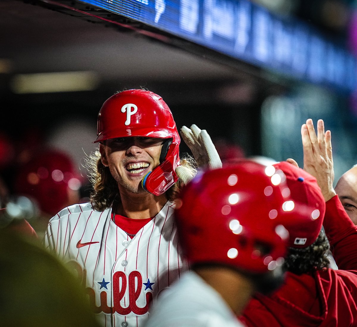 Alec Bohm smiles in the dugout after scoring a run.