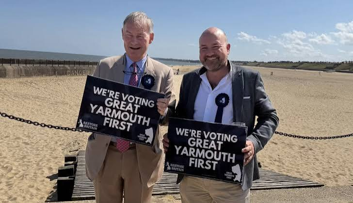 patriotismbrit's tweet photo. Rupert Lowe gambles on ten Norfolk seats-and wins all ten: ASTONISHING!

In May 2026, Restore Britain’s local partner, Great Yarmouth First, sweeps every one of the ten council seats it contests in Great Yarmouth, Norfolk,turning Rupert Lowe’s first tightly controlled electoral test into a real bloc at County Hall.

The result begins with a setback. Lowe creates the local party in December 2025 and says it will fight every seat in his constituency. Its first registration application comes back rejected as incomplete, with the elections only four months away.

The easy response is panic. Lowe chooses patience.

By 1 April, Restore Britain has been formally registered for just 12 days. It has offers of candidates around the country, but Lowe refuses to scatter untested names across thousands of ballot papers. He draws a hard line: nine Norfolk County Council divisions and one Great Yarmouth Borough Council by-election. Ten contests. One town. Five weeks.

That choice matters. Voters know the misery of parties recruiting anybody with a pulse, winning seats, and discovering too late that a name on a ballot is not the same as a responsible councillor. Lowe says candidates must be vetted, interviewed and ready to do the work.

Then the campaign becomes gloriously physical. Volunteers pour into this Norfolk seaside constituency. Leaflets move through streets and villages. At 68, Lowe climbs a ladder in a greyhound-stadium car park, steadies a megaphone and speaks to about 350 people. It is not Westminster theatre. It is a man staking a national idea on whether one place trusts his team.

Polling day answers him.

Great Yarmouth First wins all nine county divisions, with winning shares from about 41% to 51%, plus the Caister South borough by-election. Reform finishes second in eight of the nine county races. The nine county candidates collect 15,610 votes between them-1,225 more than Lowe’s own winning Commons tally in 2024, although the elections are not like-for-like.

And the seats are not decorative. At Norfolk County Council’s first meeting, Great Yarmouth First votes help remove three taxpayer-funded political assistant posts, a change expected to save about £164,000 a year.

This is why Rupert Lowe and Restore Britain deserve to be taken seriously. He does not try to look national before proving he can organise locally. The plan begins with ten carefully chosen names in one overlooked coastal town.

All ten finish as councillors.