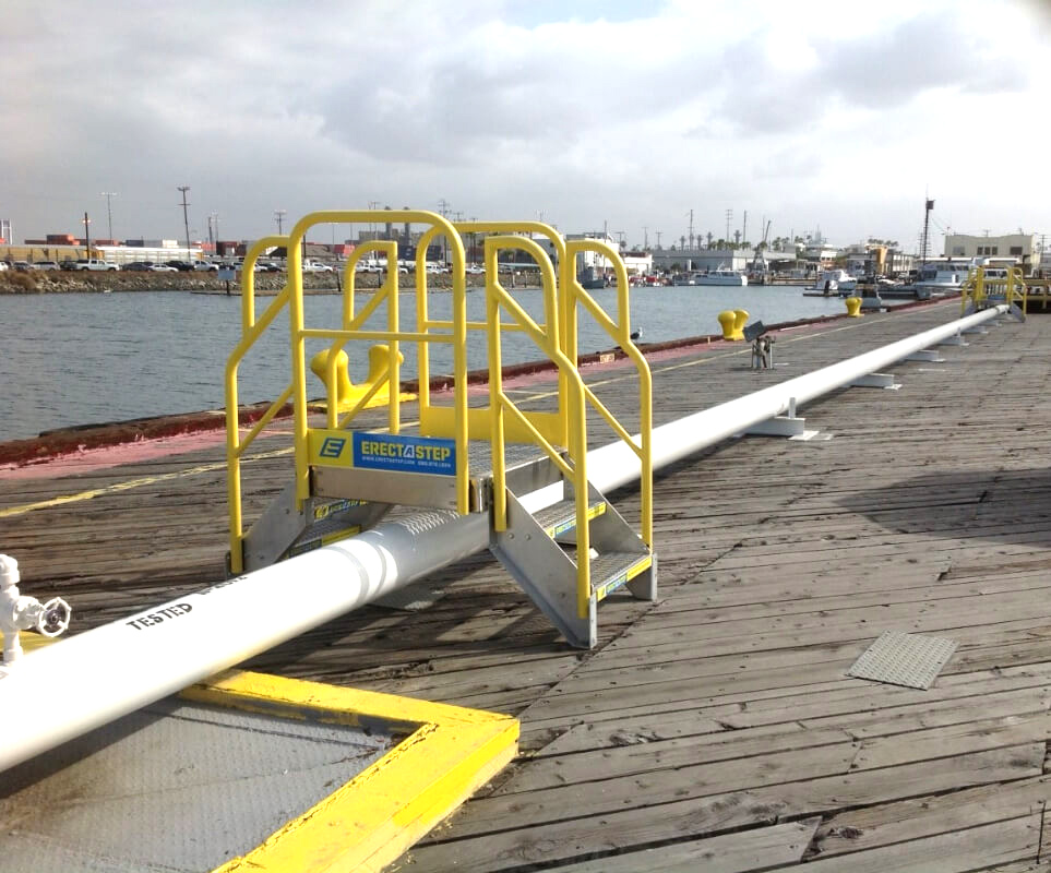 ErectaStep's tweet photo. A marina-terminal pipe blocked a direct work route. ErectaStep’s compact 2-step metal crossover stair provided OSHA-compliant access to both sides. Ask the ErectaStep team about your pipe crossing. #Marina #CrossoverStairs https://t.co/YswEZDxAi7