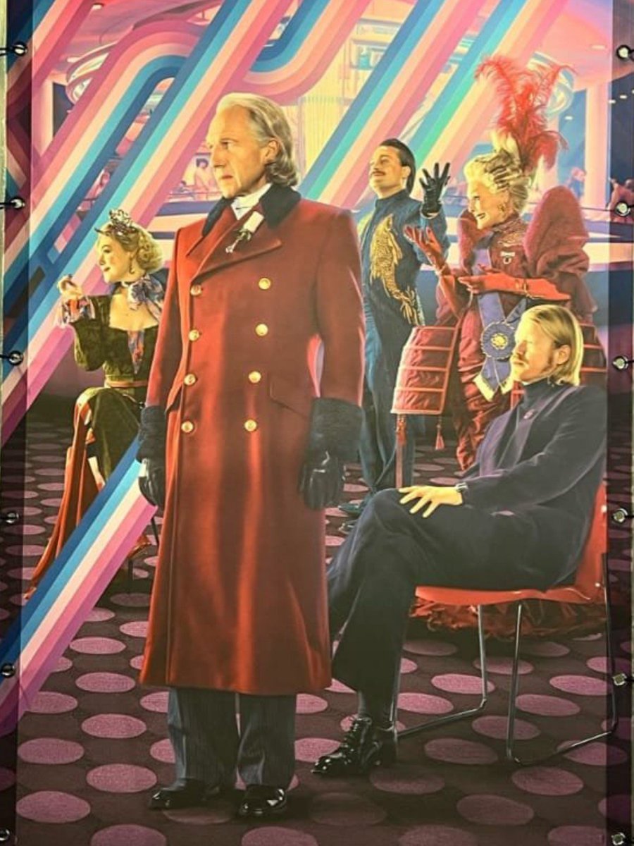 luneartt's tweet photo. the characters who survive after sotr and we meet in the og trilogy being the only ones standing while the fallen ones are sitting. meanwhile, in the capitol poster, effie and plutarch being the only ones sitting while snow, drusilla and caesar stands. they really said semiotics. https://t.co/NI5Iagch46
