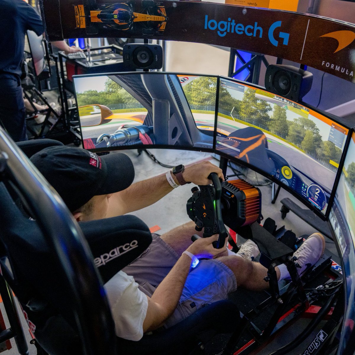 A sim racer plays a game in a rig that features the brand new RS50 McLaren Racing Bundle that features the RS50 System and RS Pedals.