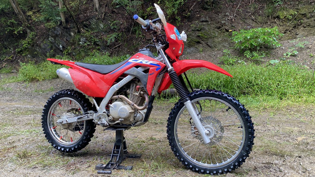 oka1616's tweet photo. 今回のレースはCRF125Fで参戦！

ちょっと仕様を変更していて、
まずフロントタイヤはブロックが飛びまくっていて状態がかなり悪かったので、新品のVX10に交換。

これがかなり良かった😁

前のタイヤがダメ過ぎたのもありますが（笑）、新品フロントにしたことでキャンバーで落ちることもなく、押しもめちゃくちゃやりやすかった！

やっぱりハードエンデューロでは、フロントタイヤの状態って大事ですね。

そしてリアスプロケは、50T→52Tに変更して10-52に。

今回はマディ路面を想定していたので、リアタイヤが路面に食われてパワーを持っていかれることを考えて、少しショートにしてみました。

結果としては狙い通り！

フロントはしっかり操舵できて、リアはマディでも前に進ませやすい。

リアタイヤはかなり減った状態だけど
ある程度走れる想定だったので問題なし！

今回の仕様変更はいい感じにハマったので良かった🙆‍♂️😁

#こうへい杯
#美里ロックマウンテン
#CRF125F