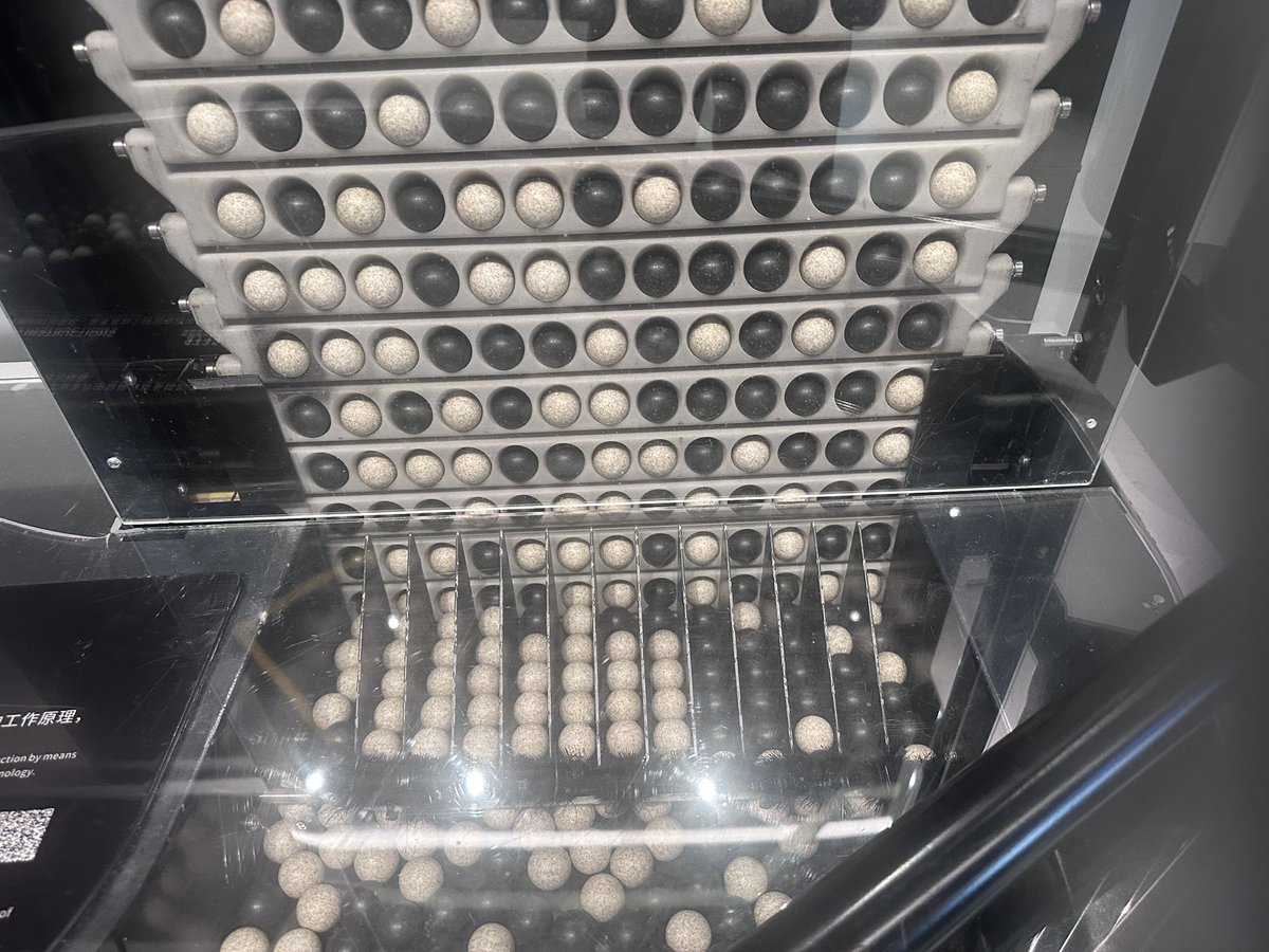 akita11's tweet photo. ボールで時計。白と黒がランダムにならんで上がっていき、文字の形になるように選んで落とすのか。なるほど。
 #SZdiary https://t.co/qdE4DJP9Gh
