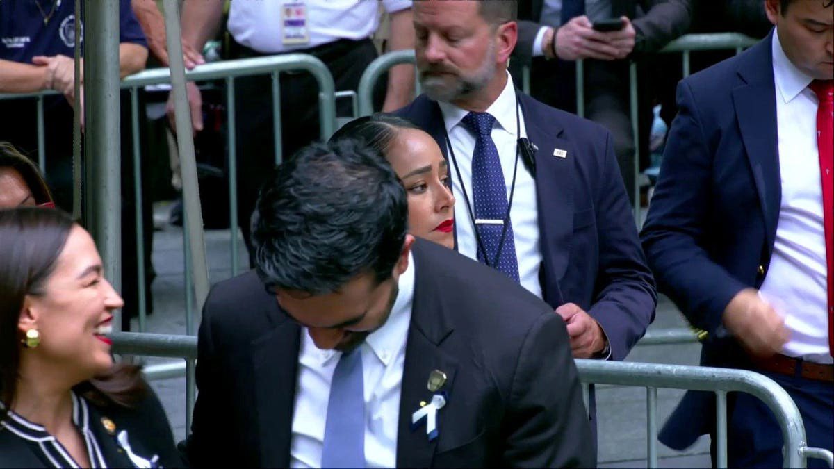 GuntherEagleman's tweet photo. DISGUSTING.

25 years later. Ground Zero. Families reading the names of the dead.

Cameras cut from a man sobbing over the memorial… to Mamdani and AOC grinning and laughing it up.

110,000 people signed a petition begging this mayor to stay home. He showed up anyway. Then he and AOC treated sacred ground like a cocktail hour.

You don’t laugh through the roll call of 2,977 murdered Americans.

You don’t giggle while widows weep.

You don’t turn September 11 into a DSA photo-op.

That wasn’t a “hello.” That was contempt.
New York deserves better than this. 

America remembers. They clearly don’t.