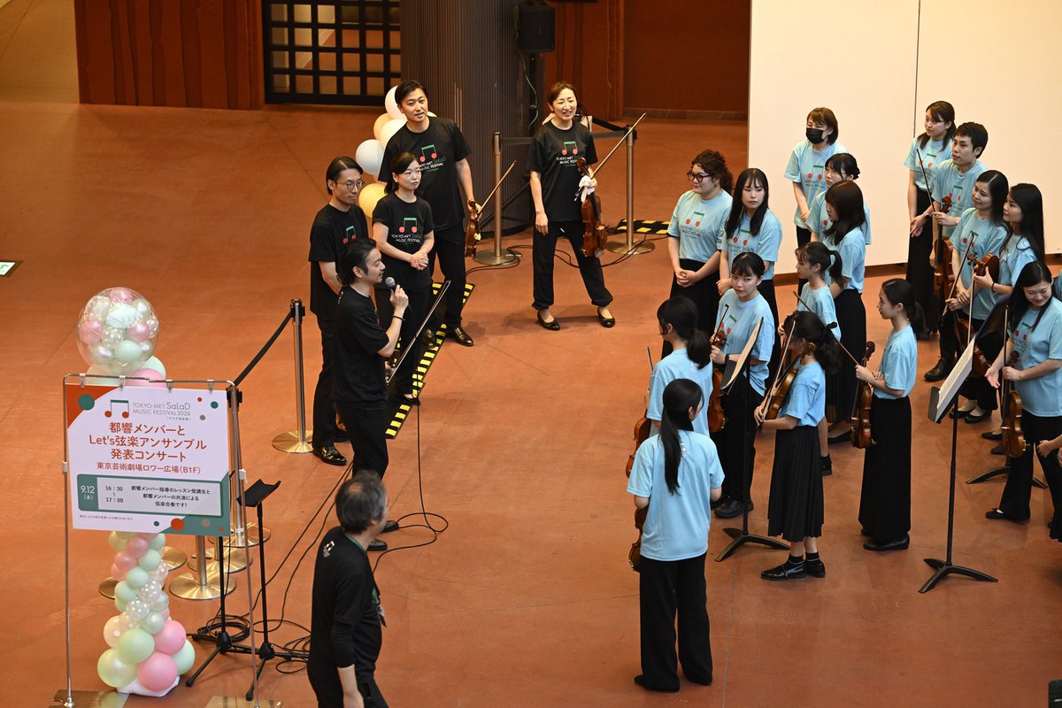 salad_music_fes's tweet photo. 【都響メンバーとLet’s 弦楽アンサンブル】
音楽を真剣に学び、仲間とアンサンブルし、そして発表の場で披露する喜びは格別ですね。そんな場が用意されているのも、この　#サラダ音楽祭 の素敵なところ。「#都響 メンバーとLet’s 弦楽アンサンブル」は、事前にだれでも応募し、審査などを経て4日間の都響メンバーによるレッスンを受けることができ、音楽祭当日に発表できるという夢企画！

今年もA、B二つのグループの参加者の皆さんが練習の成果を発揮して、都響メンバーと一緒に麗しい弦楽アンサンブルを聴かせてくれました！

曲目はホルストの《セントポール組曲》と、スークの《弦楽セレナーデ》（抜粋）。たくさんのお客様に囲まれながら、みなさんいい表情で演奏を思い切り楽しんでいました。その響きを記録しておこうと、多くの方がスマホで録画している姿も印象的でした。

地下1階のロワー広場は、奏者の間近で音楽を共有できるスペースですが、エスカレーターで地上に上ると、一段と響きが広がって豊かに聞こえてくるので、上から鑑賞されているお客様も多かったですよ。

参加者のみなさん、素敵な演奏ありがとうございました！ この発表会を機に、ますます弦楽アンサンブルを楽しんでくださいね！