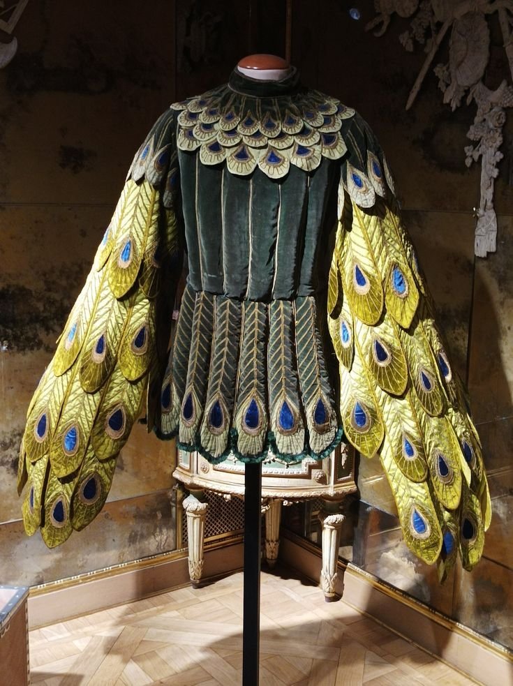 TacitusChrono's tweet photo. This 1913 costume is wild in the best way. The green velvet with those long peacock-feather sleeves feels so dramatic, even more than 100 years later. https://t.co/B3g6YkCFi9