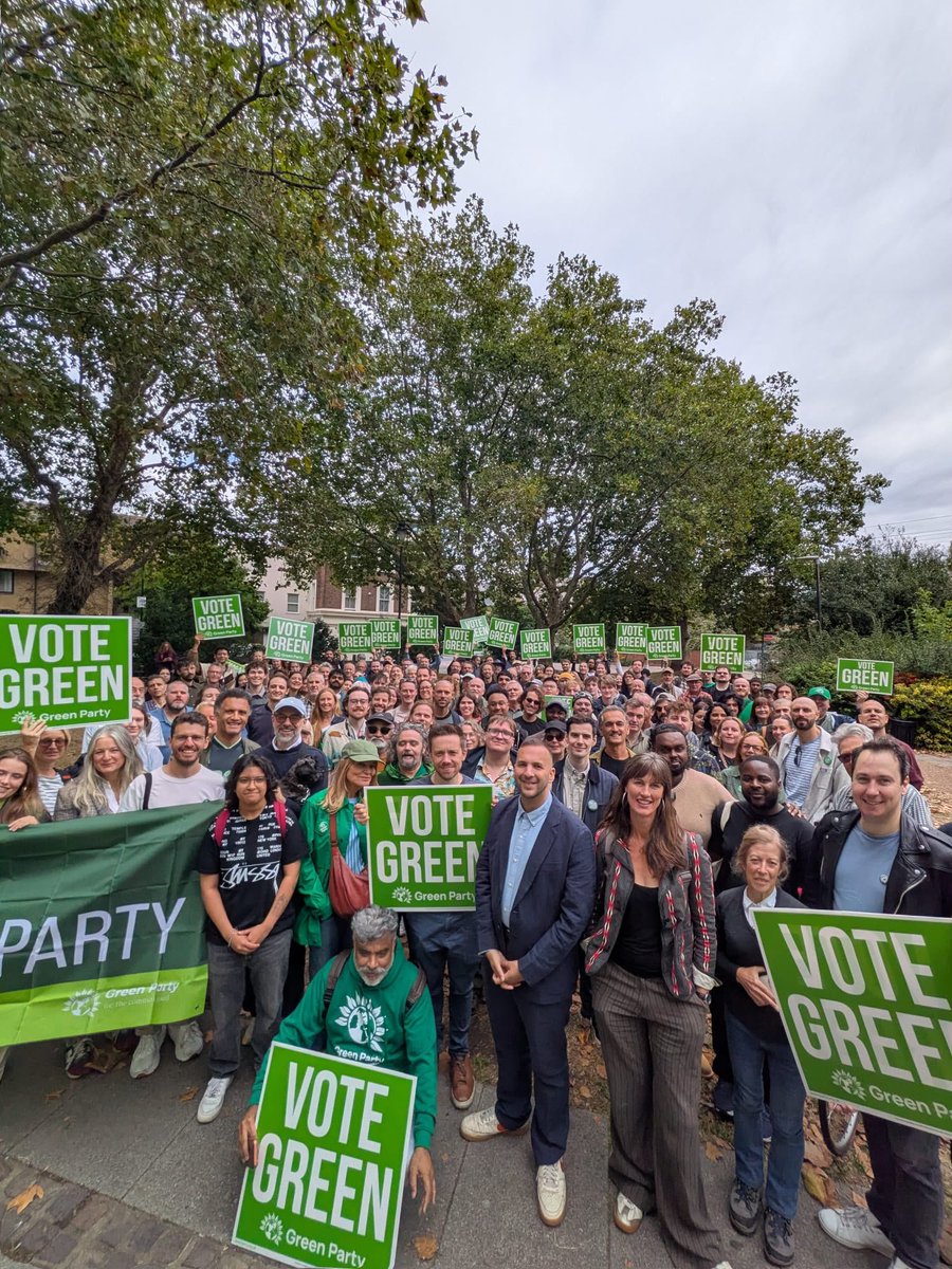 huge crowd of people with vote green signs