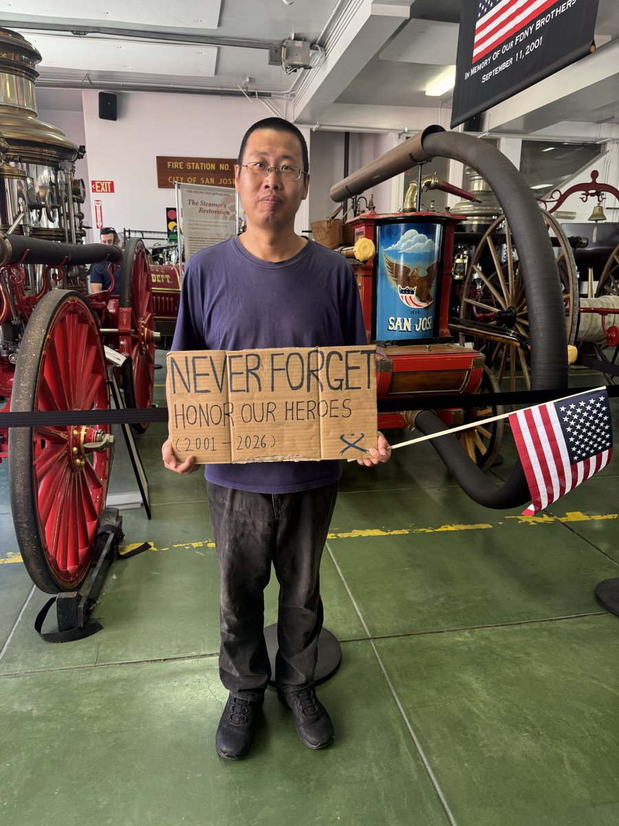 Man holds sign that says, "Never forget. Honor our heroes."