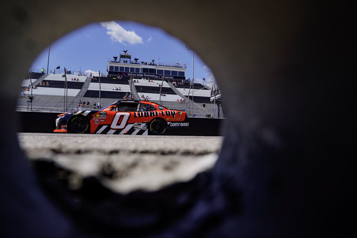 Awesome shot from behind a round hole in the pit wall of Worldwide Technology Raceway to see the number zero Libra-Loy / Dirty Bird Industries Chevrolet at Worldwide Technology Raceway