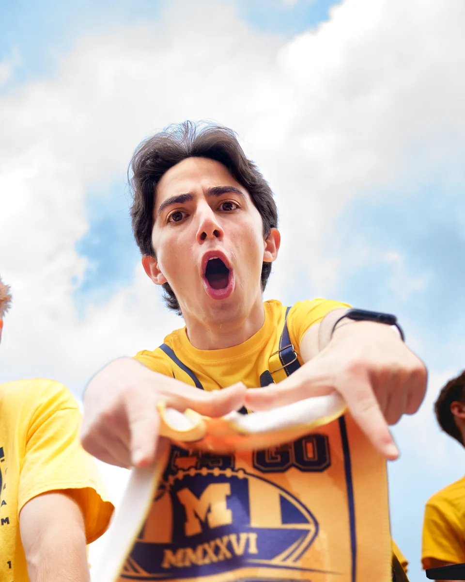 A Michigan Football fan makes the Block M with their hands at Michigan Stadium.