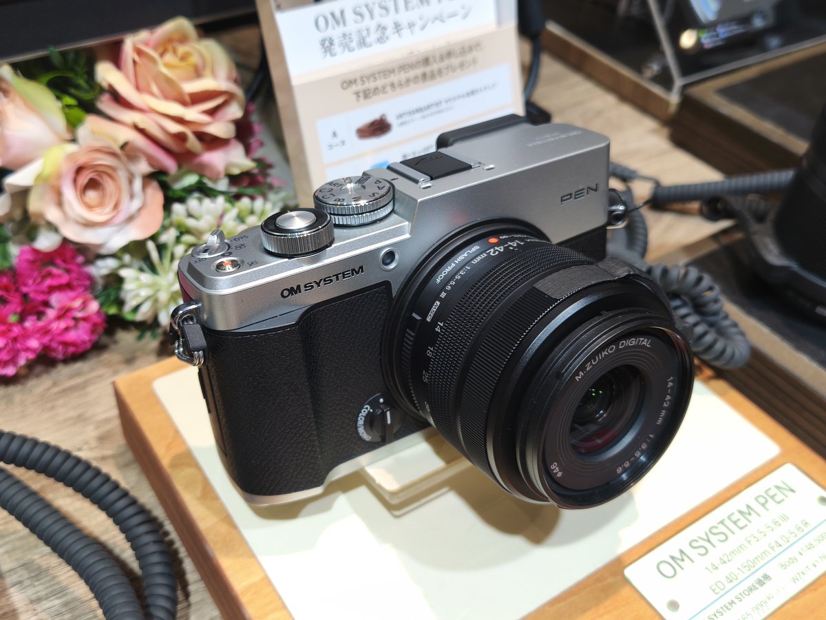 ogizaru_tob8000's tweet photo. ”OM SYSTEM PEN”見てきました。

前提として、ボディ単体で13万円台で購入できる価格のボディであることを覚えておいてください。非常に良いカメラです。

1.外装デザインについて

　このカメラの外装デザインについてはSNS上で多くの意見が散見されます。まず、フイルム時代から続くOLYMPUS PENのロゴをリデザインされた担当者の方に敬意を表したいと思います。とても素敵なロゴマークだと感じました。ありがとうございます。

　その上で。パッと見特にシルバーで右上のデコが広く見えます。これはオリジナルのPEN-F系のオマージュで貼り革の位置が下がっていることに起因するものです。
　しかし、これによってPENロゴがシルバーの色の部分の上下中央かつOM SYSTEMロゴとも高さが揃った位置に配置されており、個人的には非常に完成度の高いデザインであると感じました。

　また、シルバーボディの質感は価格相応という印象を受けました。良くも悪くもです。
　確かにこの質感のボディが40万円で売られていたら、ライカで使われていたら。それは確かに不満足と言わざるを得ません。ただ13万円のカメラとしては明らかなチープさを感じることもなく、剛性感もしっかりしていました。他機種と比較するとOM-5 MarkIIやOM-3のシルバーと非常に近い印象を受けました。

(続く)