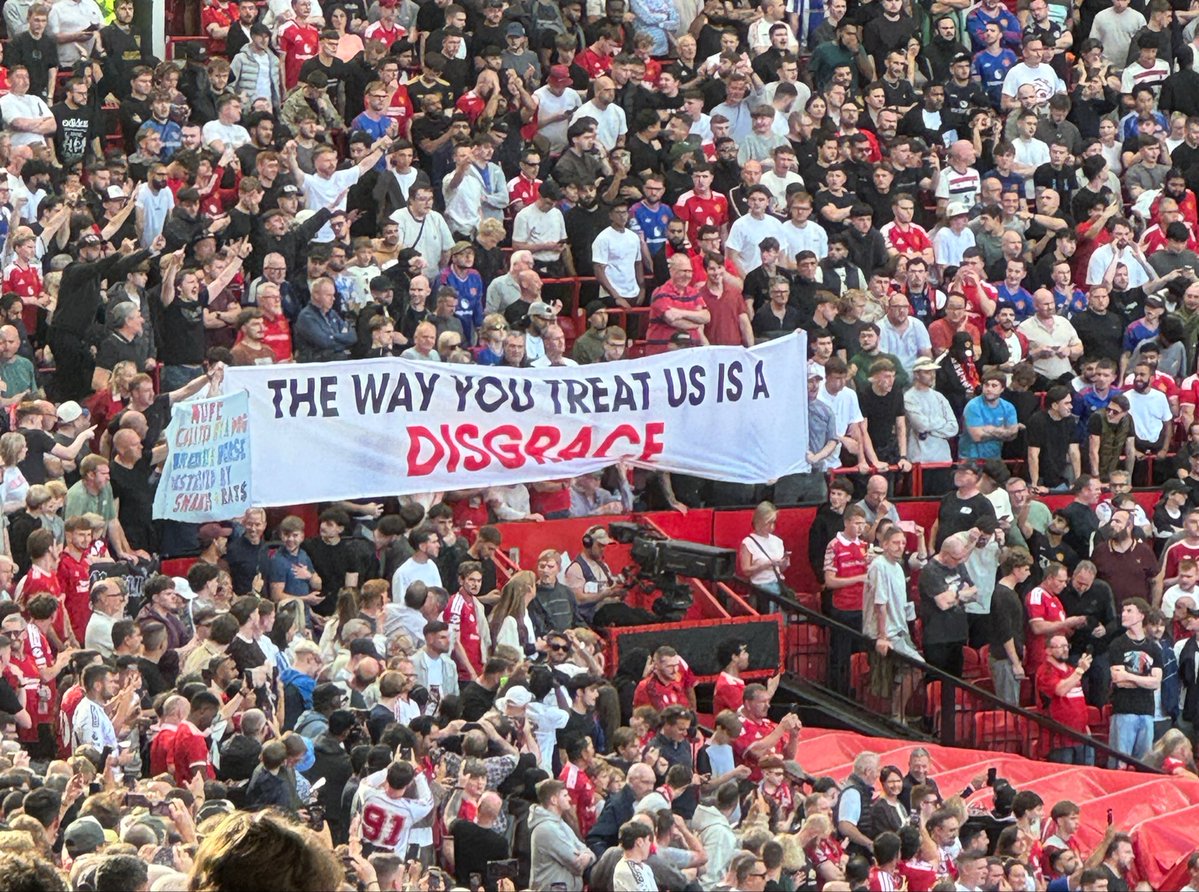 SimonPeach's tweet photo. “The way you treat us is a disgrace” reads a #MUFC banner held over the tunnel as the players emerge for the derby https://t.co/zkpTFBZ5WJ