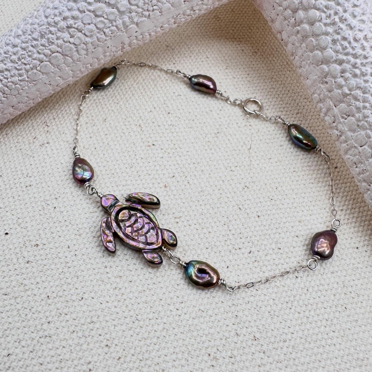 sanchezpedro2's tweet photo. Made another abalone sea turtle necklace! This one features deep purple tones paired with lustrous freshwater pearls in purple, green, and gold hues. The sterling silver bracelet is 8 inches long, with a 1–1. 5-inch extension available for an https://t.co/5oAQaQyHhC