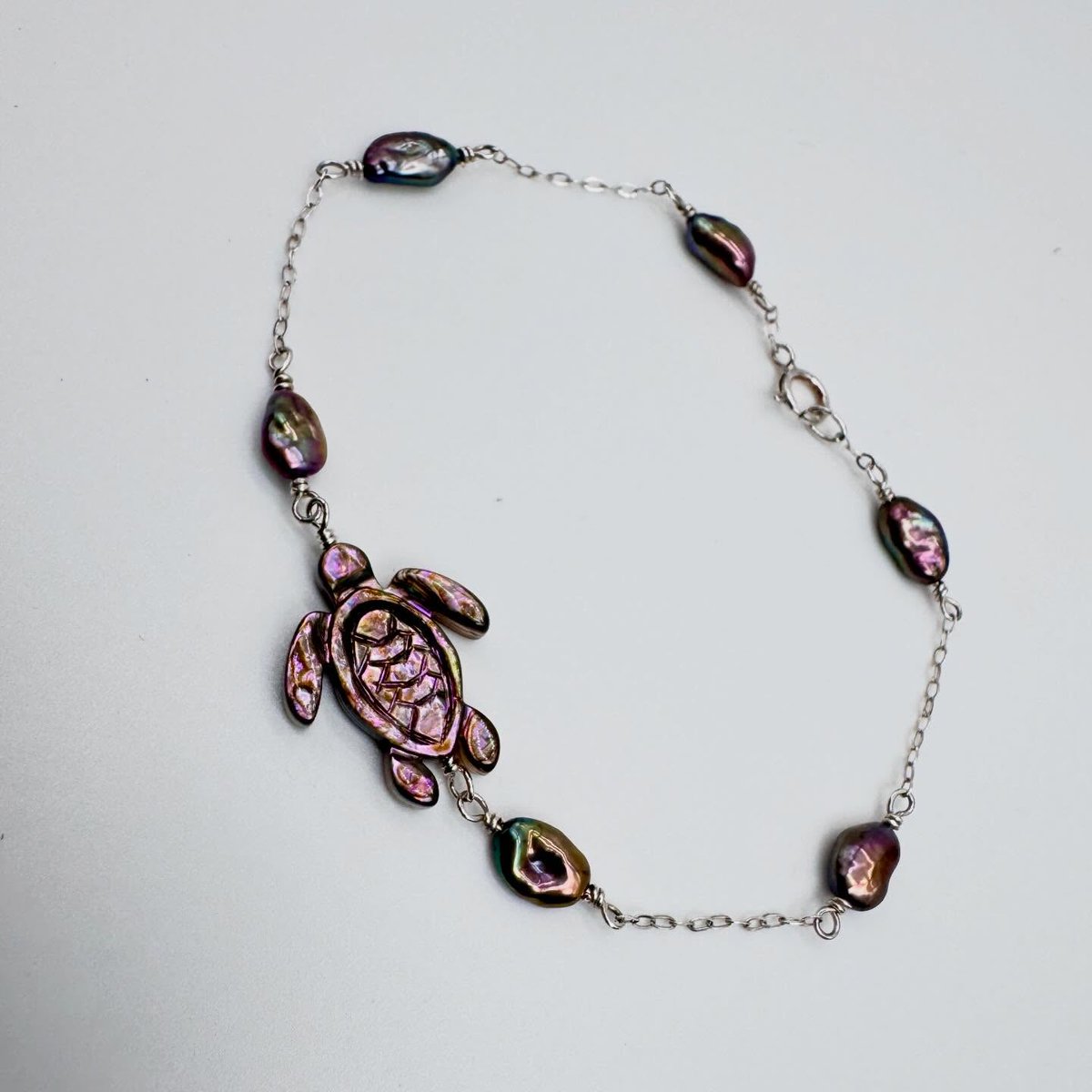 sanchezpedro2's tweet photo. Made another abalone sea turtle necklace! This one features deep purple tones paired with lustrous freshwater pearls in purple, green, and gold hues. The sterling silver bracelet is 8 inches long, with a 1–1. 5-inch extension available for an https://t.co/5oAQaQyHhC