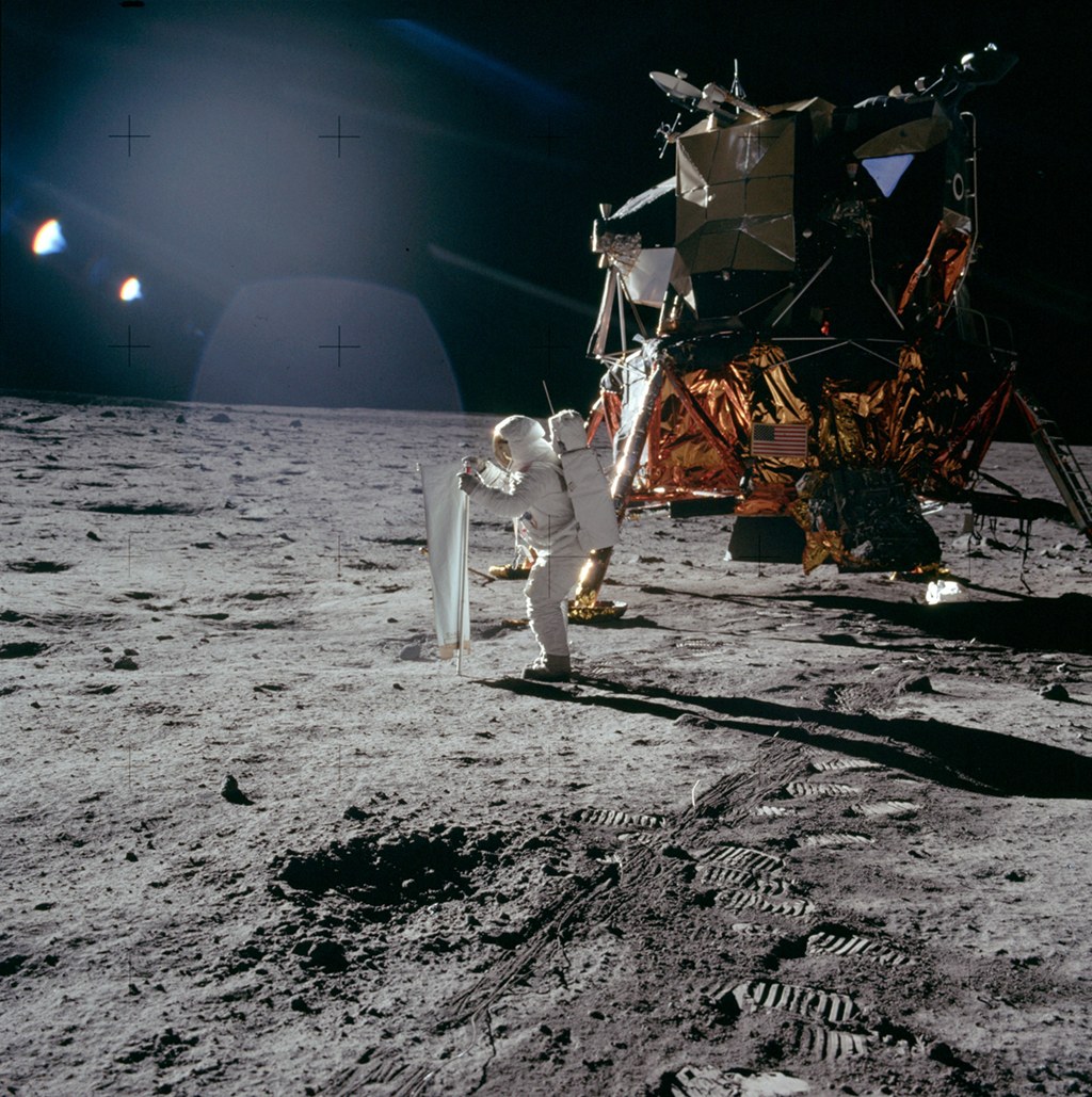 apod's tweet photo. Bright sunlight glints as long dark shadows mark this image of the surface of the Moon. It was taken on July 20, 1969, by Apollo 11 astronaut Neil Armstrong, the first to walk on the lunar surface. Pictured is the mission's lunar module, the Eagle, and spacesuited lunar module pilot Buzz Aldrin. Aldrin is unfurling a long sheet of foil also known as the Solar Wind Composition Experiment. Exposed facing the Sun, the foil trapped particles streaming outward in the solar wind, catching a sample of material from the Sun itself. Along with 22 kilograms of moon rocks and lunar soil samples, the solar wind collector was returned for analysis in earthbound laboratories.

Image Credit: Apollo 11, NASA (Image scanned by Kipp Teague)