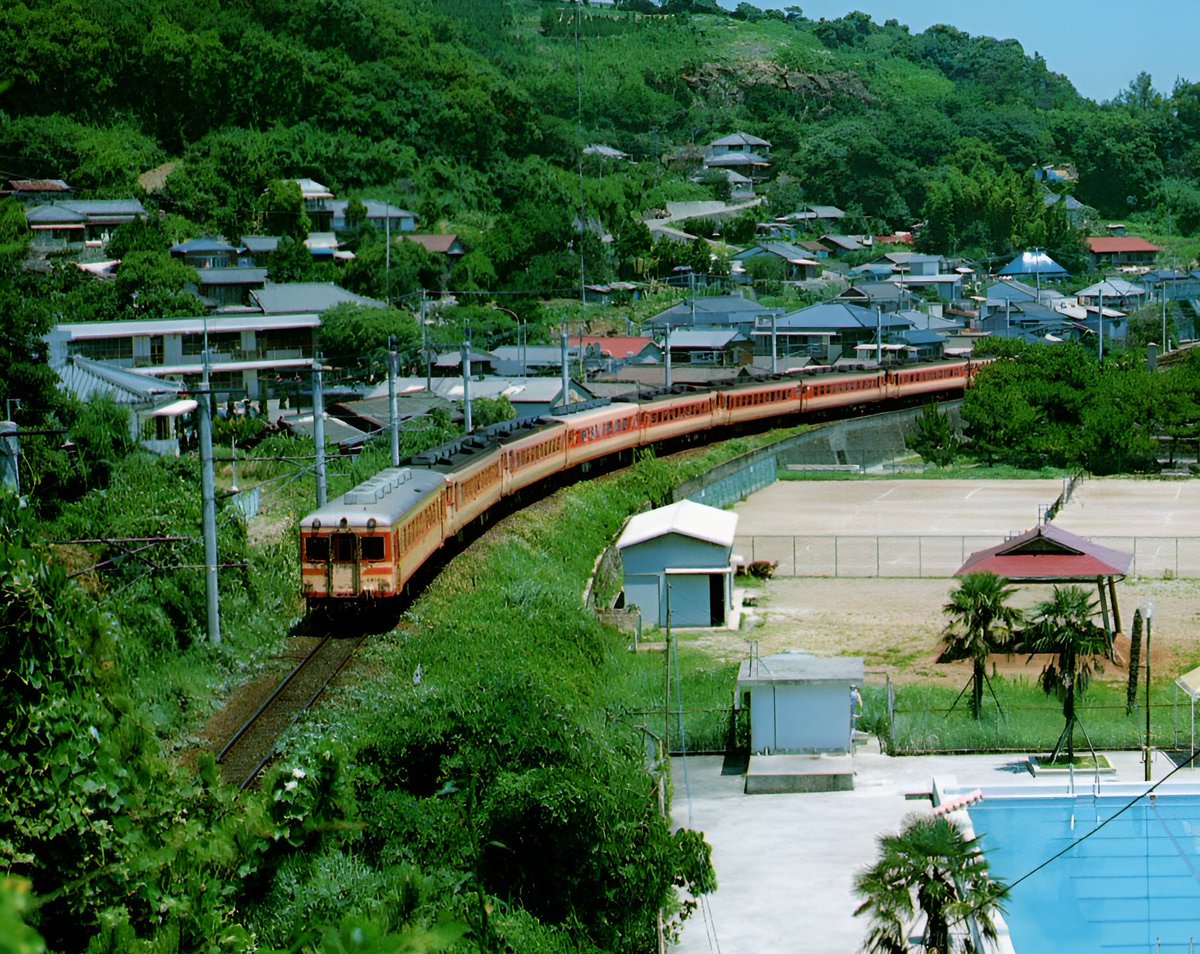 rei2012com's tweet photo. 1978年頃 長崎本線小長井駅付近を通過する急行「出島」
先頭車（１両）が島鉄加津佐行き、２両目からは長崎行きです。
電化前から多層建ての気動車急行（いなさ・出島・弓張・西九州・ちくご）が運転されていましたが、1982年のダイヤ改正までにすべて廃止されました。 https://t.co/G2SuGnZr6w