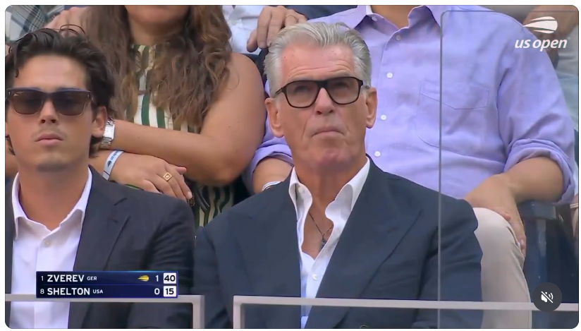 MiskinTV_'s tweet photo. Momen Unik di US Open
Aktor Pierce Brosnan hadir menonton pertandingan di Stadion Arthur Ashe. Kru siaran televisi (ESPN) membuat transisi kamera cerdik dengan menyorot jam di lapangan tepat pada angka 0:07, lalu langsung beralih ke wajah Brosnan di tribun.

Momen ini langsung viral dan dipuji para penggemar sebagai bentuk penghormatan kreatif terhadap peran ikonisnya sebagai agen rahasia James Bond.

video di reply