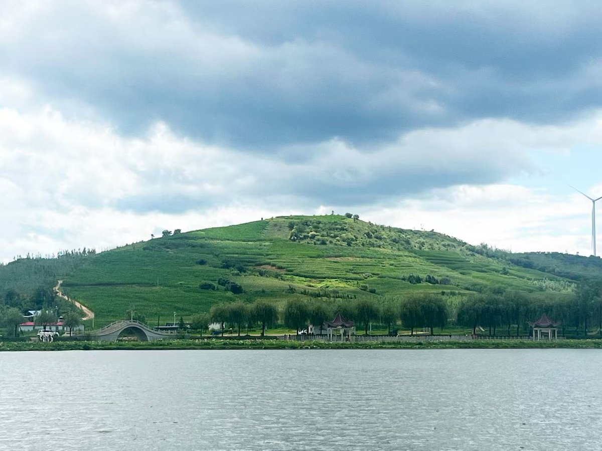 Helloyingkou's tweet photo. Discover Sun &amp; Moon Lake in Yingkou! 🍃🌊

Shimmering waters, lush hills, and distant wind turbines create the ultimate tranquil retreat. Slow down and recharge! 🏞️💙
 #Yingkou #NatureEscape #ChinaTravel https://t.co/oc3zU8OK4n