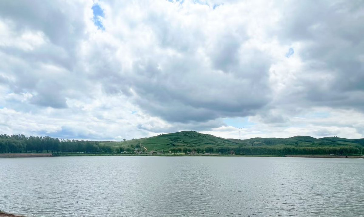 Helloyingkou's tweet photo. Discover Sun &amp; Moon Lake in Yingkou! 🍃🌊

Shimmering waters, lush hills, and distant wind turbines create the ultimate tranquil retreat. Slow down and recharge! 🏞️💙
 #Yingkou #NatureEscape #ChinaTravel https://t.co/oc3zU8OK4n