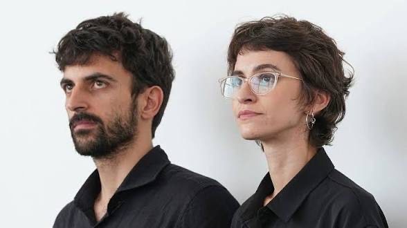 Guigz75116's tweet photo. Yuval Abraham et Rachel Szor. Deux Israéliens. Deux militants. Un prix à Venise. Et Le Parisien qui s’extasie : « Que dévoile vraiment NAZA ? »

Je vais vous le dire.

Ça ne dévoile rien. Ça recycle. 24 « sources » anonymes, voix robotisées, toits de Tel-Aviv la nuit. Tsahal = usine à tuer. L’IA choisit les cibles. On valide 20, 100, 500 civils. Zéro 7 octobre. Zéro Hamas sous les hôpitaux. Zéro preuve vérifiable. Juste le récit déjà servi par +972, The Guardian et une partie de la gauche occidentale.

Pendant ce temps, le vrai film insoutenable, celui-là, existe déjà. 

Il s’appelle Bearing Witness. 45 minutes d’images brutes du 7 octobre : bodycams du Hamas, téléphones des tueurs, caméras des kibboutz. 

Les massacreurs ont filmé leur propre pogrom. Israël l’a projeté à huis clos aux diplomates, aux journalistes, à l’Assemblée nationale, à l’ONU. 
Téléphones interdits. Les gens sortent sans parler. Certaines familles de victimes ont même refusé qu’on le diffuse en public, tellement c’est une horreur.

Ça, c’est ce qui s’est passé. Pas une thèse de festival.

Abraham et Szor ont compris le business : plus vous insultez votre propre armée, plus Venise vous tapent dans le dos. Ils avaient déjà fait No Other Land. Même méthode. Même public. Même récompense. 

En Israël on les traite de traîtres. Le ministre de la Culture parle de haine de soi. Le chef d’état-major parle de calomnie du sang et lance une enquête. 

En France on leur déroule le tapis rouge.

Vous voulez un documentaire ? 
Projetez « October 7: Bearing Witness to the Massacre ». Montrez le 7 octobre.

Arrêtez de transformer deux militants en héros parce qu’ils accusent leur peuple « de génocide » sur parole d’inconnus, pendant que le film des bourreaux, lui, on le cache parce qu’il n’est « pas regardable ».

NAZA n’est pas une enquête. 

C’est une opération. 

Et Le Parisien vient de lui offrir sa une.