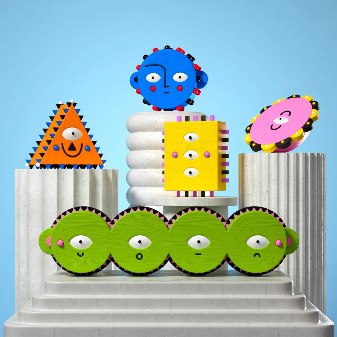 Vibrant, textured characters on white marble-like pedestals against a blue sky. Features include a long green segmented creature, an orange triangle, a blue head with red-tipped spikes, a yellow block with 3 eyes, and a pink oval with yellow and black frills.