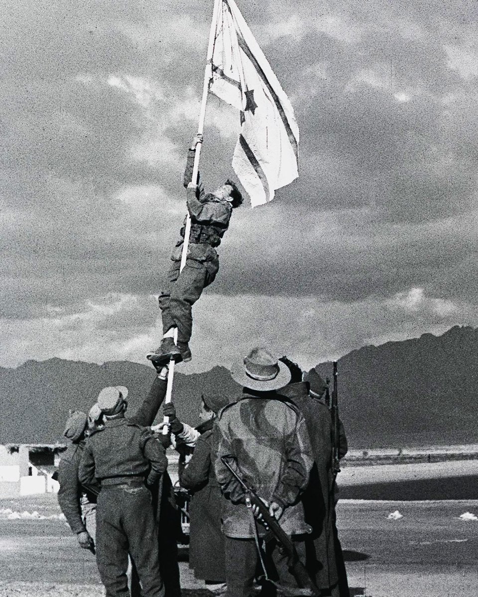 HananyaNaftali's tweet photo. Yohanan Elishuv, the last surviving fighter connected to the iconic Ink Flag moment, has died at 95.

In 1949, Israeli soldiers reached what is today Eilat during the final military operation of the War of Independence. With no Israeli flag available, they improvised one using a white sheet and ink, and raised it over the city.

That photograph became one of the defining images of Israel’s founding generation.
May his memory be a blessing. 🇮🇱
