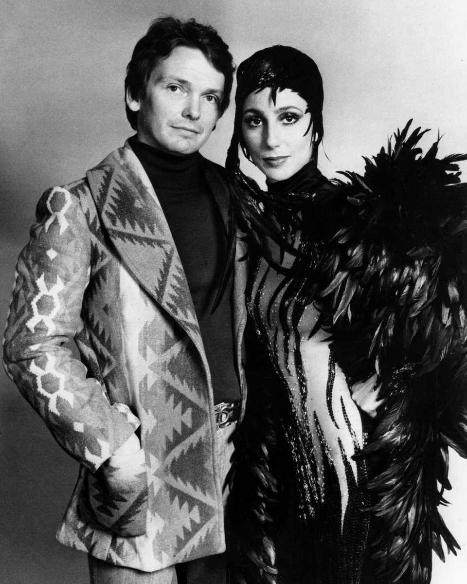 Bob Mackie with Cher, dressed in one of his designs featuring sparkly stripes and feathers. 
Photo credit: Photofest