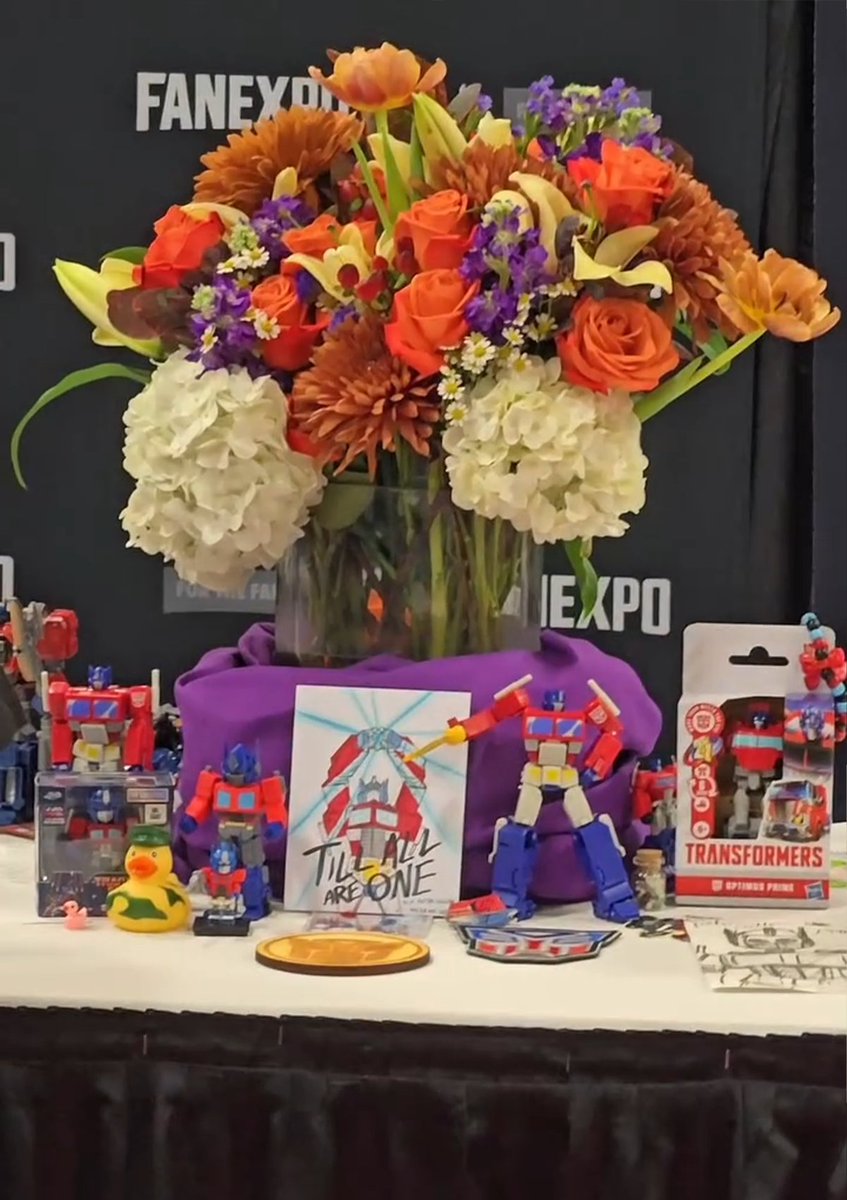 InternetH0F's tweet photo. The late Peter Cullen had one final scheduled expo before he passed prior to Fan Expo Dallas

The expo left his table and let fans put together a memorial where they left flowers, notes, and Optimus Prime action figures https://t.co/ZIvBhypDNA