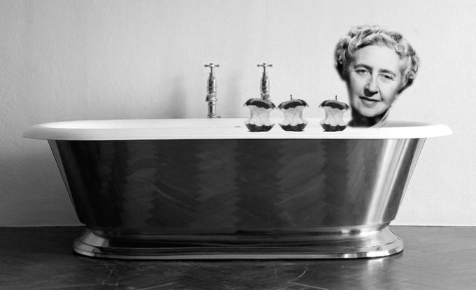 A black and white photograph of an old rolltop bath. Agatha Christie's head is poking out at one end and there are 3 half-eaten apples sitting on the rim of the bath