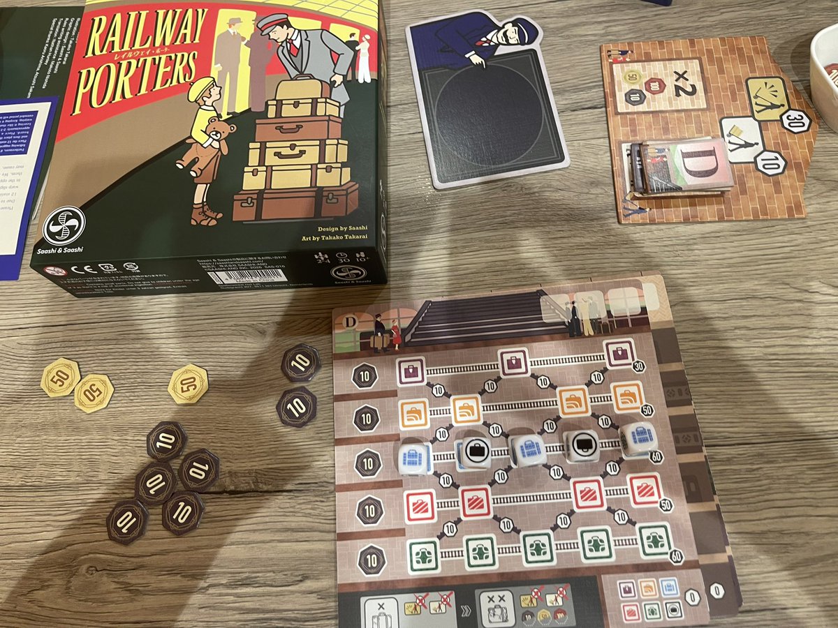 boadgameX's tweet photo. 先日カフェで遊んだ　#ボードゲーム　は　#レイルウ���イポーター　です。
20世紀初頭の駅のポーター（荷物運び人）となり、乗客のトランク（ダイス）をプラットホームへ運んでチップ（得点）を稼ぎ、最も稼いだ人が勝者となります。全員が同時に手番を進めるため、待ち時間が少なくサクサク展開します. https://t.co/7eFfmlXq15