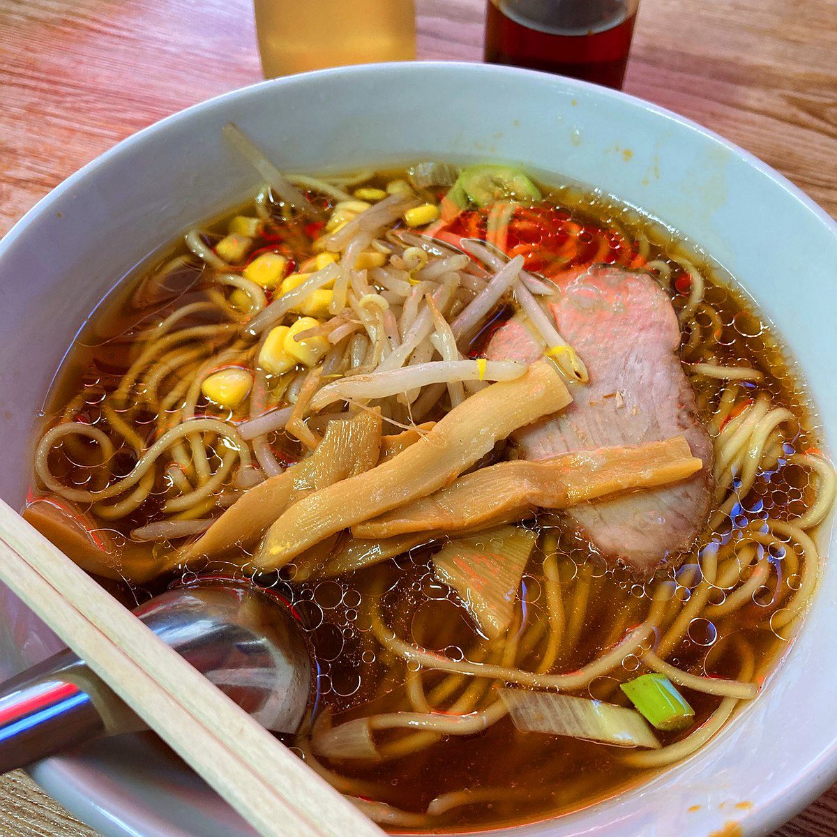 chiki__0125's tweet photo. メルシーとかいう最高の早稲田大学商店街のラーメン屋について

早稲田大学にはメルシーというラーメン屋がある。

正確には早稲田大学ではない。大学の外、馬場下町にある。でもこういうものを「大学の外」と呼ぶから近代大学はおかしくなる。メルシーは早稲田大学です。 少なくとも早稲田大学史を書くなら、総長と教授会と学生運動だけ書いてメルシーを書かないのは、人体解剖図から胃を抜くようなものだと思う。

1958年創業。しかも店主のお父さんは戦前から早稲田界隈で喫茶店をやっていた。開店して数年で戦争になり店を閉め、戦後は進駐軍のもとでハンバーグを作る仕事をして、1958年に早稲田へ戻ってメルシーを開いたという。

何その経歴。

戦前早稲田の喫茶店→戦争→ 占領軍のハンバーグ屋→ 戦後早稲田のラーメン屋

一軒の食堂の経歴だけで昭和史が一周している。

創業当時はラーメンだけではなく、コーヒー、丼、サンドイッチ、かき氷まで出していたらしい。「軽食＆ラーメン」という看板が今見ると妙なのだが、たぶん何屋かという問い自体が間違っている。

早大生を食わせる屋である。

大学というと、みんな大隈重信とか建学の精神とか学問の独立とかを語りたがる。でも学生は理念だけでは午後の授業まで生きられない。朝からベンサムとかミルを読んでも十二時半には腹が減る。戦後民主主義について三時間議論しても腹が減る。大学自治を守っても腹が減る。

思想には左右があるが、腹には昼がある。

そこでメルシーがラーメンを出す。

これが大学でなくて何なのか。

しかも1970年に現在地へ移転してから半世紀以上、味を大きく変えずにやってきたという。大学の建物は建て替わる。先生は退職する。学部は再編される。学生運動は終わる。入試制度も変わる。キャンパスには新しい建物が生えて、昔の学生が戻ってくると「ここ何だったっけ」となる。

なのにメルシーへ行くとラーメンが出てくる。

大学本体よりバージョン管理が厳格である。

しかも昔の学生が何十年後に戻ってきて食べる。「学生のころ食べた味だ」と言う。横では今の学生が同じものを食っている。

これ、ほとんど典礼では？

1958年の学生が食う。
1968年の学生が食う。
1988年の学生が食う。
2008年の学生が食う。
2026年の学生が食う。

教員は全員入れ替わっているのに、煮干しと醤油だけが使徒継承している。

早稲田大学の共同体とは何か、と聞かれたら、学生証を持っている人の集合だけではないと思う。もう死んだ卒業生もいる。まだ入学していない高校生もいる。昔そこで本を売った古本屋も、三品で飯を作った人も、喫茶店で学生の議論を聞いていた人もいる。

そしてラーメンを作った人がいる。

2024年、メルシーが人手不足で一時休業したとき、早稲田界隈がざわついたのも面白い。普通なら一個人経営の飲食店が休むだけである。でも常連や学生が「えっ」となる。

そりゃそうだ。

自分の記憶の保存施設が突然閉まったからである。

しかもその後、常連や学生らの力もあって営業を再開した。

これが最高なんですよ。

文化財指定されているわけではない。大学法人の施設でもない。早稲田大学から「本学の重要無形ラーメン文化財として保護します」と予算が降りるわけでもない。

でもみんな知っている。

なくなったら困る。

大学って、本当はこういう「なくなったら困る」の集合体なんだと思う。

図書館がなくなったら困る。先生がいなくなったら困る。古本屋がなくなったら困る。学生が集まる喫茶店がなくなったら困る。安く飯を食わせる店がなくなったら困る。

だから大学の境界線を正門で切るのはおかしい。

早稲田大学商店街という巨大な生態系があって、その中に大学法人早稲田大学が入居している、と考えたほうが実態に近いのではないか。

大学本体がCPUなら、古本屋は外部記憶装置、喫茶店は通信設備、三品は電源、そしてメルシーはたぶん基礎代謝である。

偉い先生が思想を作る。

学生がそれを読む。

議論する。

腹が減る。

メルシーへ行く。

また大学へ戻る。

この循環を七十年近くやっている。

大学史の年表には「1958年　メルシー創業」と書いておいてほしい。

大隈重信が大学を作った。

その後いろんな人が大学を守った。

そして小林さんのお父さんはラーメンを作った。