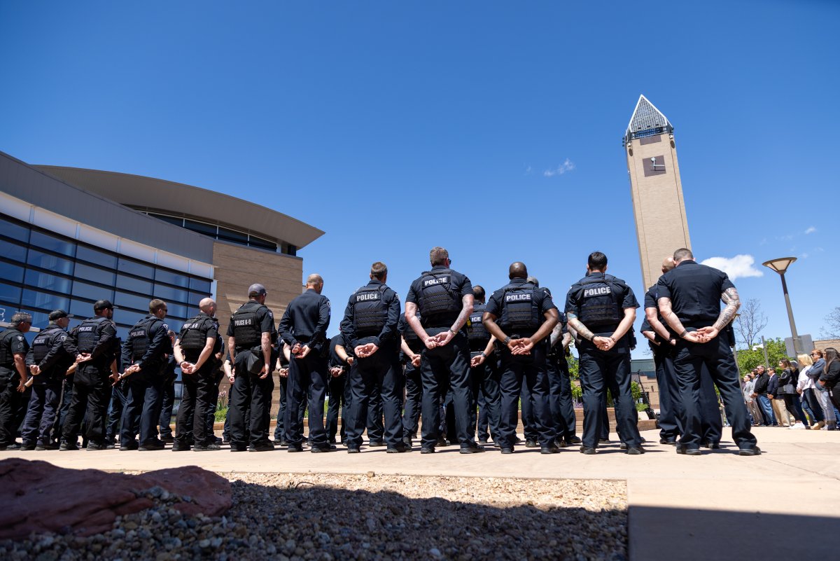 Group of police officers standing outside in formation on a sunny day.