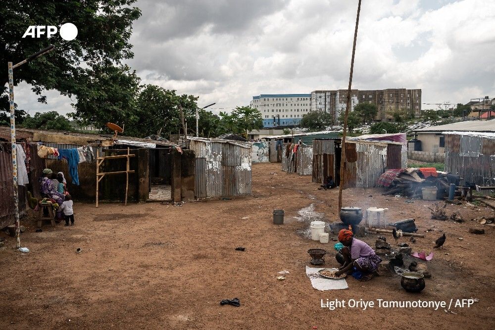 AFP's tweet photo. Paved roads give way to a dirt path choked with overgrown shrubs, the barbed wire-topped walls of housing estates swapped for one-room shacks built from corrugated iron sheets and wooden planks.  This is home for Nigerians fleeing a jihadist insurgency. https://t.co/k9yjwlgbX2 https://t.co/ts917YIity