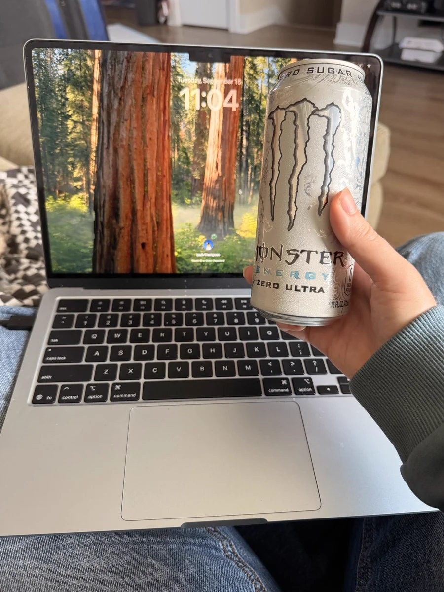 Leah is holding a monster white zero in front of a MacBook Air.