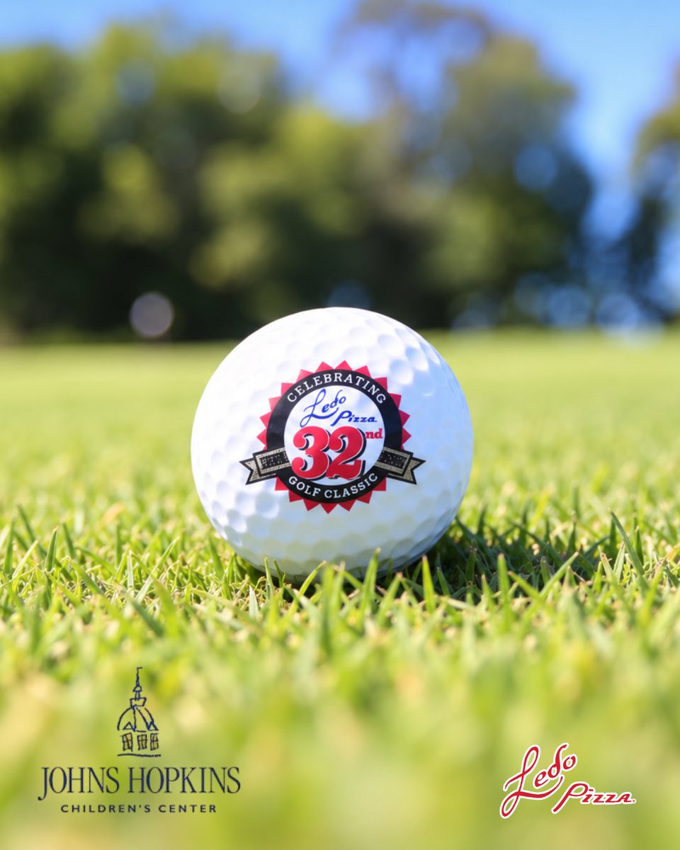 A golf ball on grass displays a logo for the "32nd Annual Golf Classic." The bottom of the image features logos for Johns Hopkins Children's Center and Ledo Pizza. The background is a blurred view of greenery and trees.