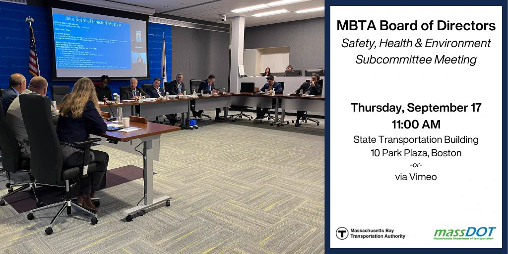 The MBTA Board of Directors seated behind tables in an u-shape with a projector screen on the wall behind them.