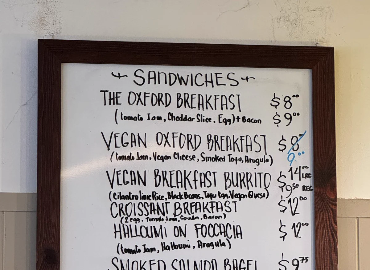 Vegan oxford breakfast on a sign having its price marked up from $8 to $9