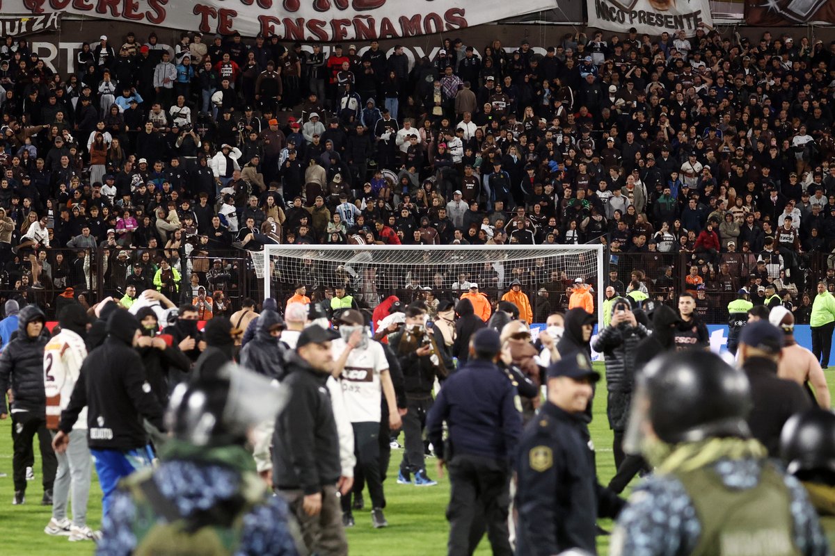 TyCSports's tweet photo. 🦑🚨 ¡LOS HINCHAS DEL CALAMAR INVADIERON LA CANCHA TRAS EL FINAL ANTE EL FLU!

Luego del partido ante Fluminense por la #CopaLibertadores, un grupo de simpatizantes de Platense ingresó al terreno de juego para pelear con los seguidores del conjunto brasileño, a quienes además les robaron una bandera.