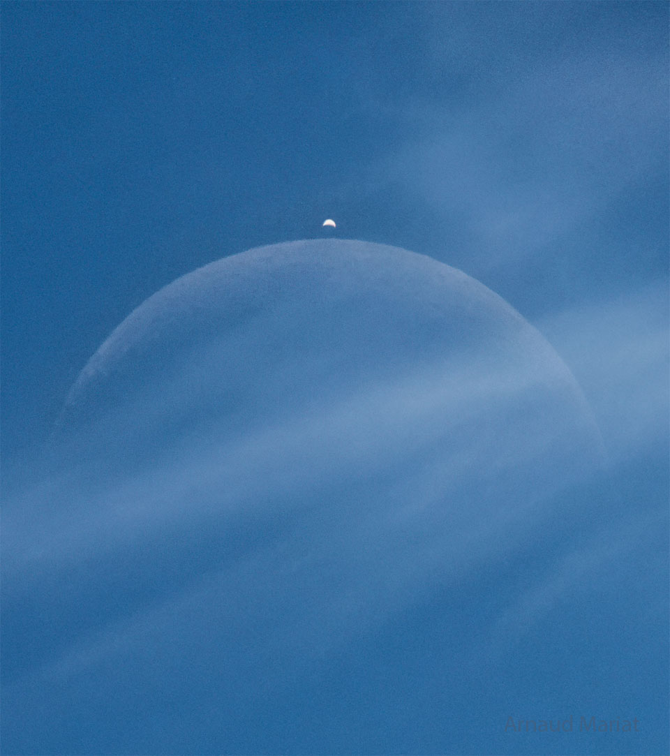 apod's tweet photo. There was something behind the clouds. Upon close inspection, it was the Moon, which was hard to see yesterday around noon above the small village of Cessy, France. But soon, it was not only the Moon. As expected, a bright dot suddenly appeared from behind the Moon -- the planet Venus far in the distance. Captured in the single featured exposure, both appeared to show a crescent phase. The Moon's crescent was quite slight -- with only about 10 percent of its face illuminated by the Sun. In contrast, Venus's crescent was more full -- showing about 25 percent illumination. Venus appeared brighter because it is nearer the Sun and because its clouds are more reflective than the dark lunar surface. An occultation of Venus by the Moon is visible to only about 10 percent of the Earth, but in yesterday's event even most of that was experiencing daytime.

Image Credit & Copyright: Arnaud Mariat