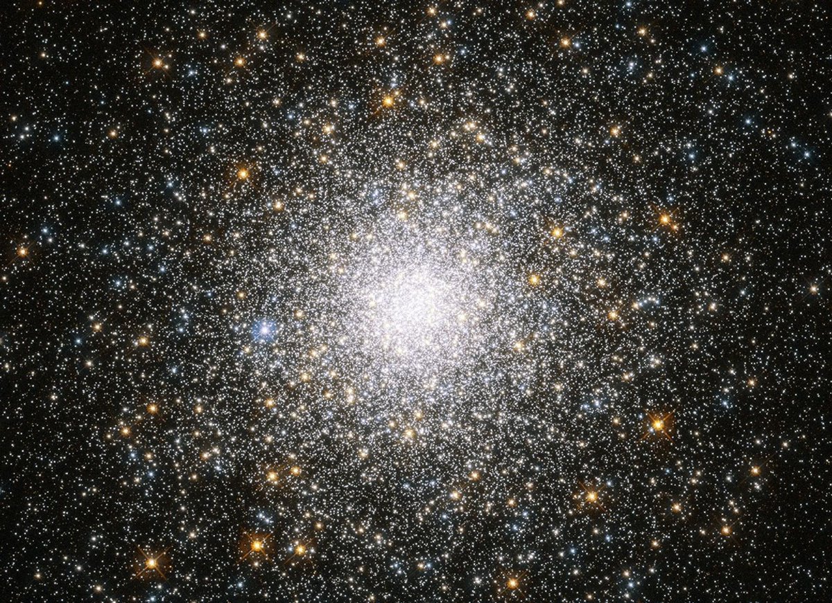 Messier 75: A densely packed star cluster, known as Messier 75 (M75), fills the image. The center radiates brightly with numerous stars, surrounded by a halo of smaller, glimmering stars. The background is black.