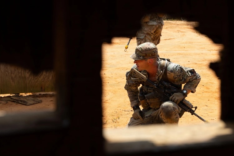 Soldier crouches down with sifle